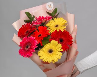 Букет из 7 гербер стандарт микс в стильной упаковке с зеленью  small - 4