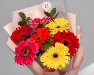 Букет из 7 гербер стандарт микс в стильной упаковке с зеленью  small - 5